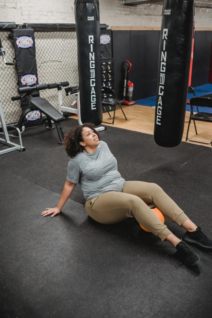 woman sitting on gym floor